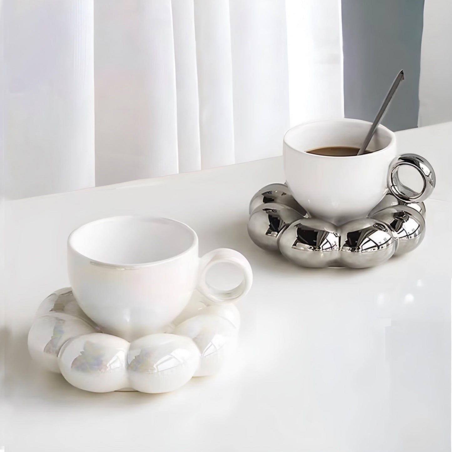 a coffee cup sitting on a table next to a cup of coffee