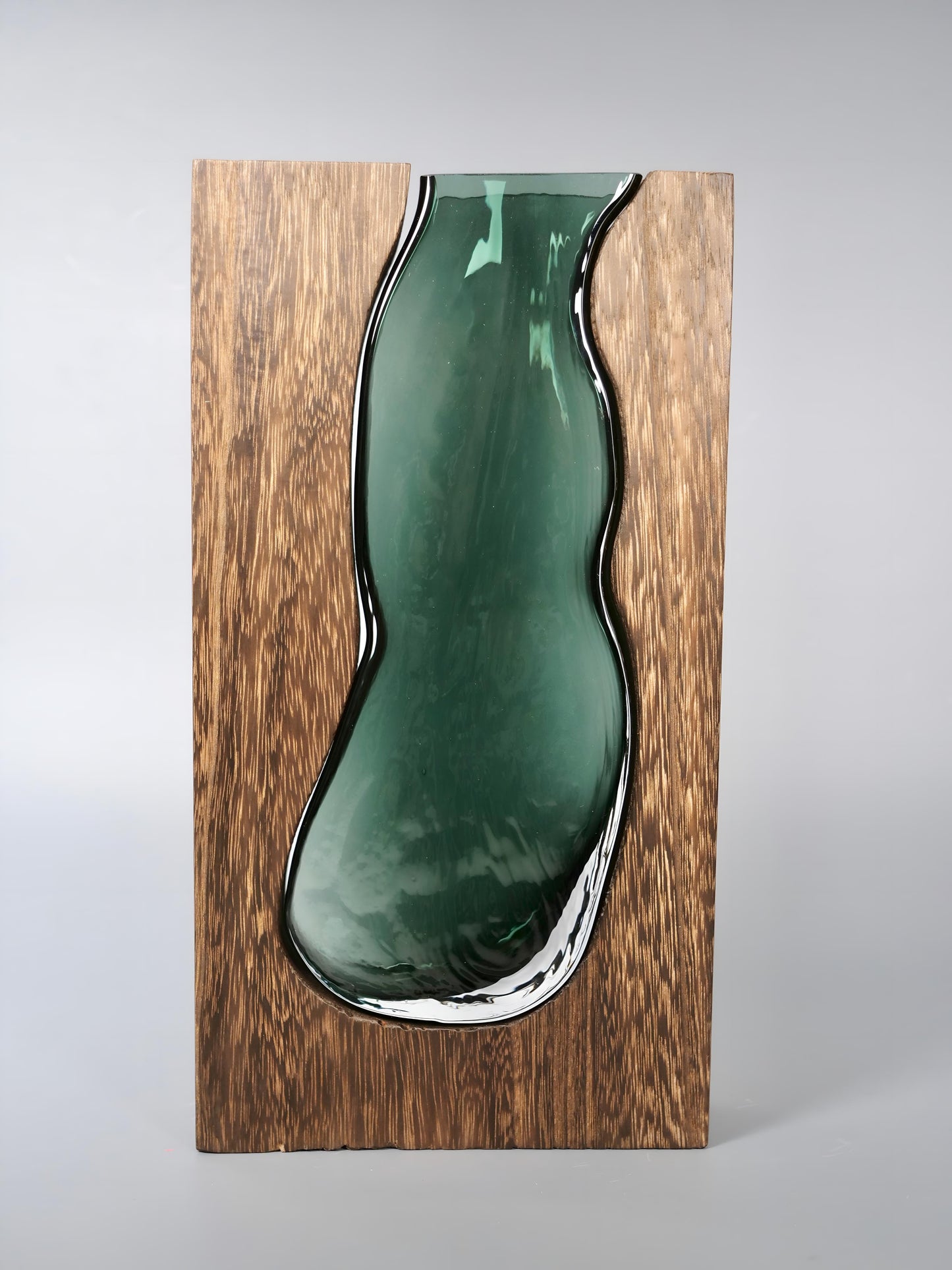 a green vase sitting on top of a wooden shelf