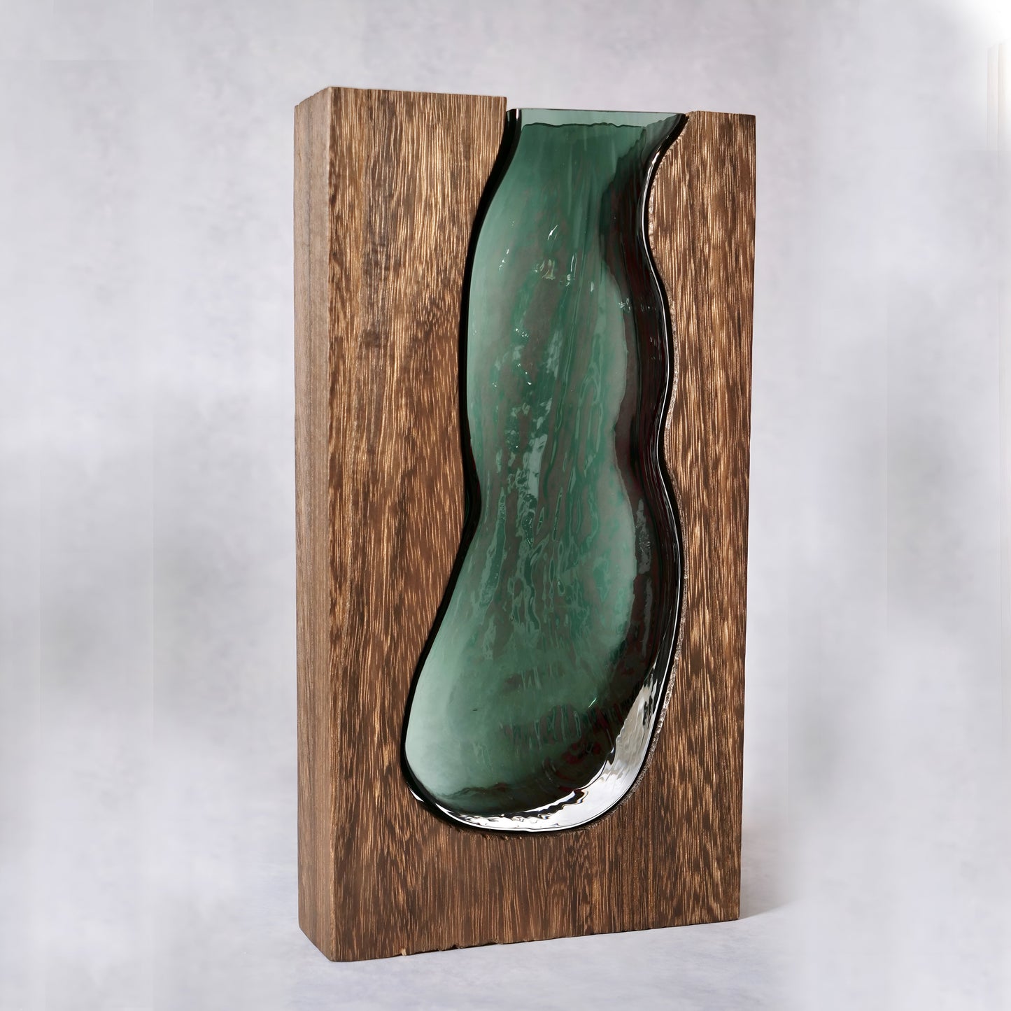 a green vase sitting on top of a wooden shelf