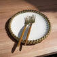 a golden clock is on a wooden table 