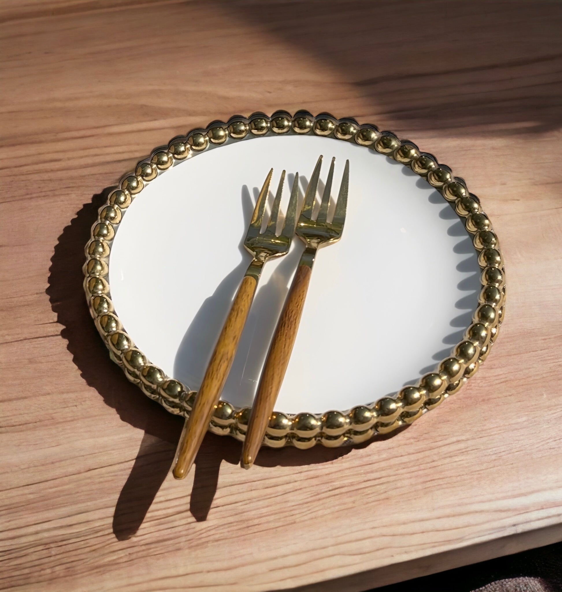 a golden clock is on a wooden table 