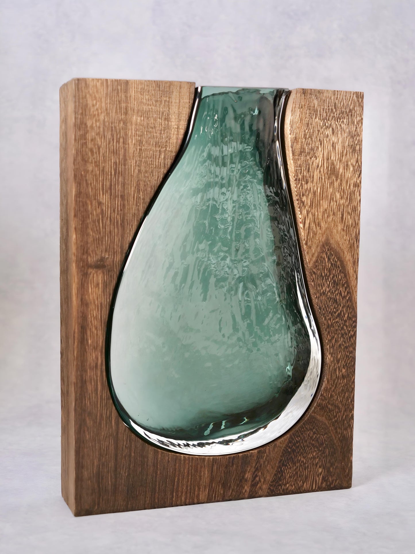 a green vase sitting on top of a wooden shelf 