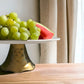 a bowl of fruit sitting on a table 